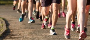 Legs of runners on a dirt path next to a lake