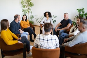 Support group sitting in chairs having a discussion