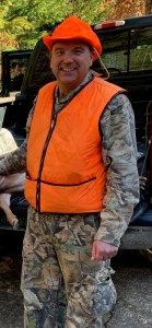 David Cole wearing camouflage, an orange vest, and an orange hat