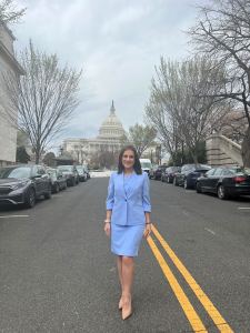 Dorothea Staursky wearing a blue dress and blazer, standing outside Congress