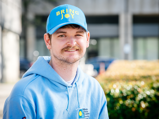 Photo of Joseph Thompson in a blue sweatshirt and blue baseball cap