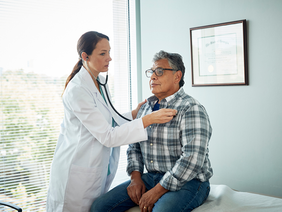 Female doctor listening to male patient's heartbeat with a stethoscope