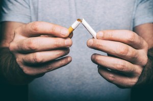 Quitting smoking - male hand crushing cigarette