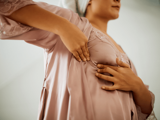 Adult female conducting a breast self-exam