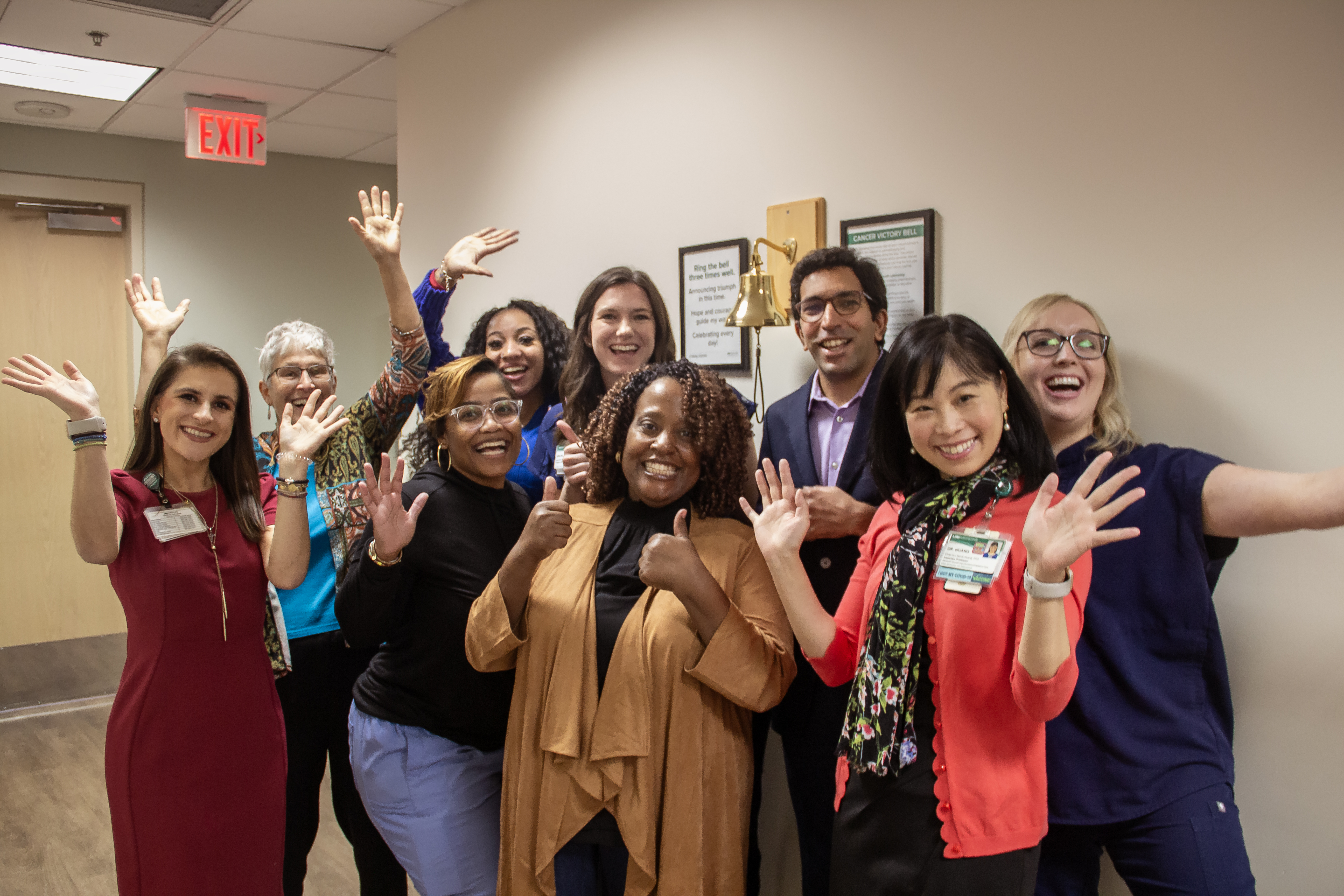 Group photo of people celebrating the victory bell