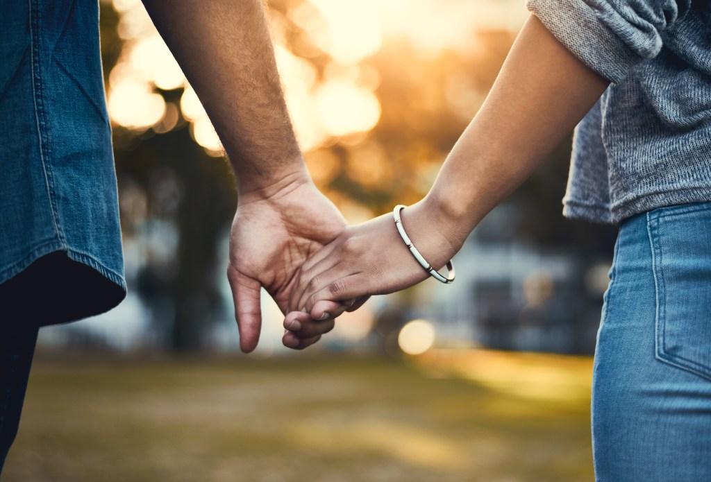 Closeup shot of a couple holding hands outdoors