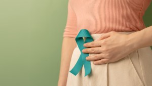 Woman Holding Teal Ribbon on Lower Abdomen