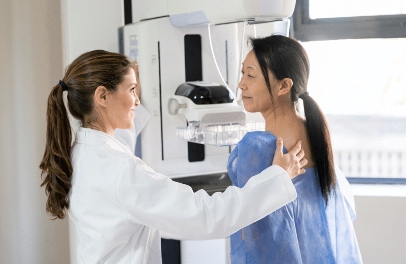 Female doctor conducting mammogram on female patient