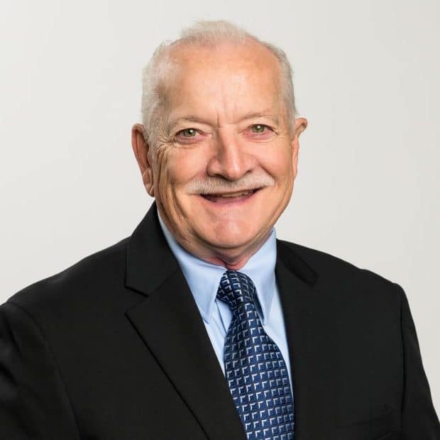 An elderly man – Fred Halstead – in a black suit with a blue tie.