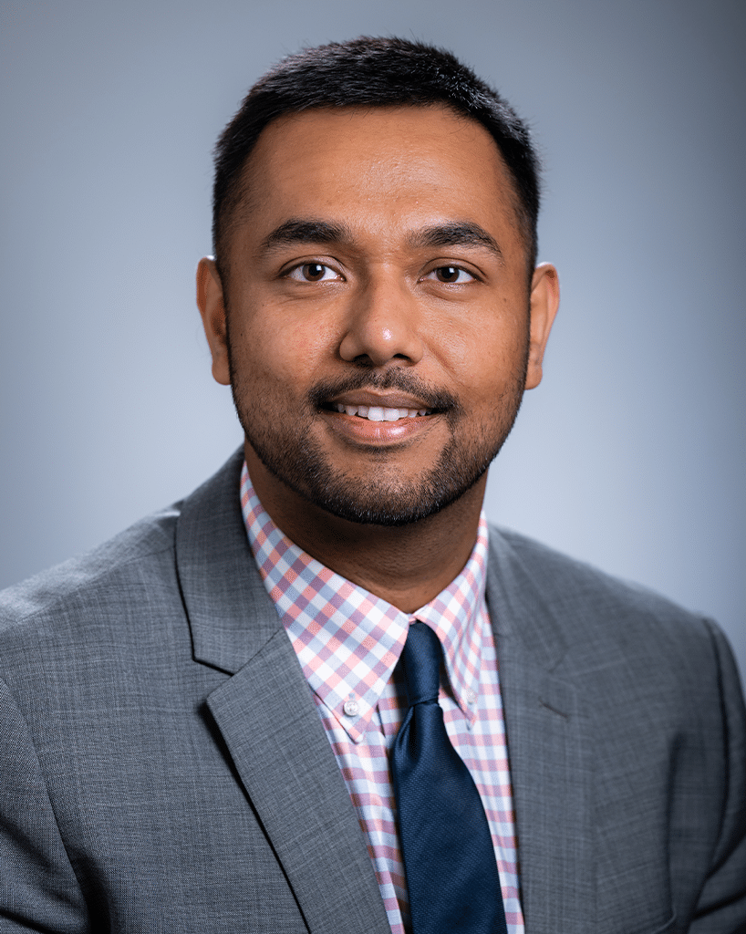 A headshot of a scientist in a gray suit and blue tie; Aakasi Desai, M.D., MBBS, MPH.