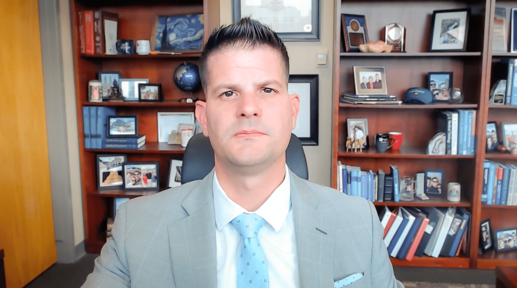 A doctor in a gray suit – Corey Speers, M.D. – presents via Zoom at ASCO 2026.