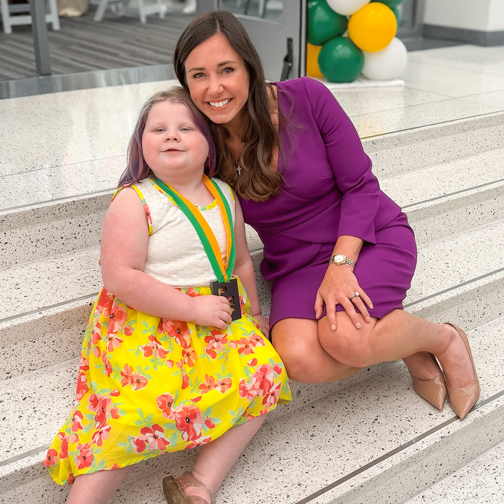 A photo of US Senator Katie Britt sitting with Piper Diamond on a set of stairs at the 2026 Iron Strong Awards.