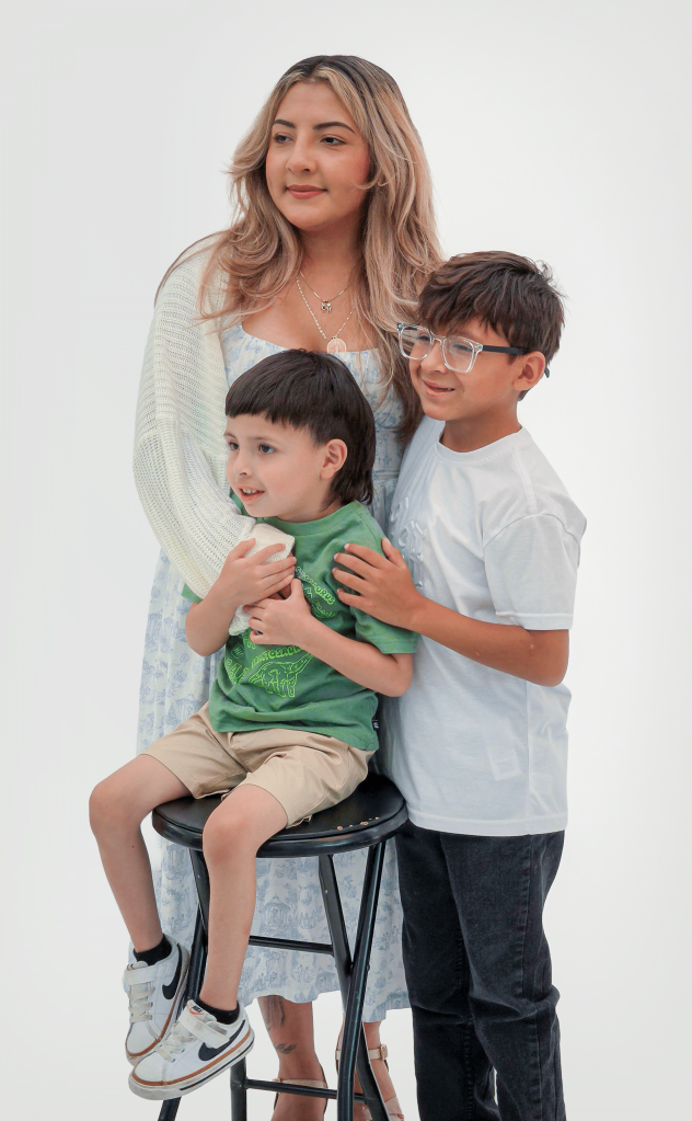 Karla Lopez standing at the Iron Strong Awards with her two sons.