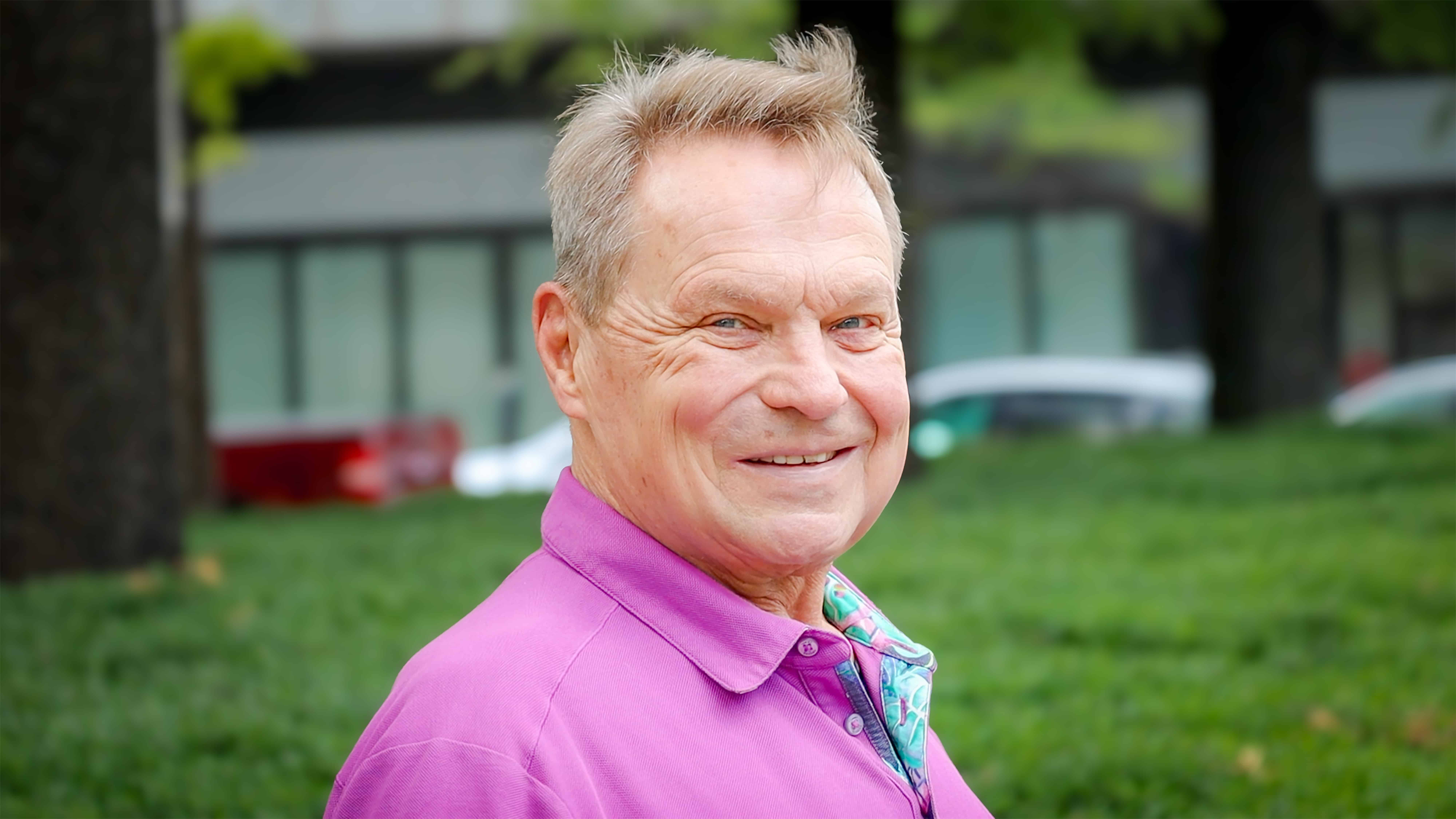 Iron Strong awardee Virgil Lugar stands outside of the Kirklin Clinic, smiling to camera.