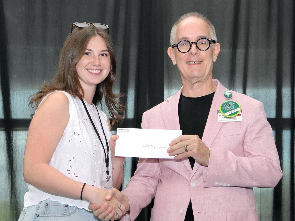 Caroline Ennis receives an award at the 2026 O'Neal Research Retreat.