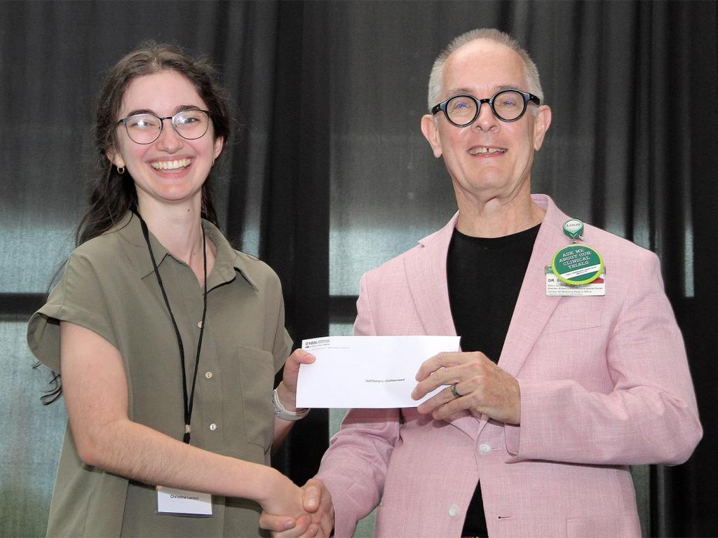 Christina Larson receives an award at the 2026 O'Neal Research Retreat on behalf of Richard Laube.