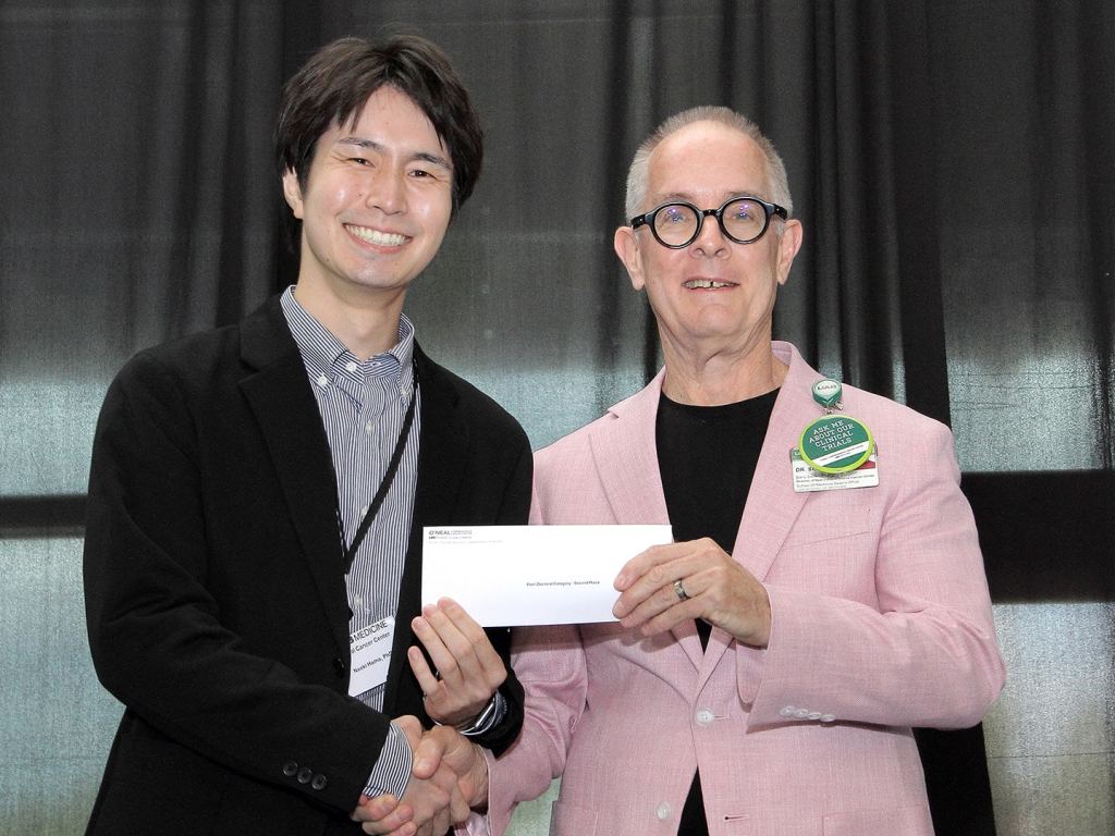 Naoki Hama receives an award at the 2026 O'Neal Research Retreat.