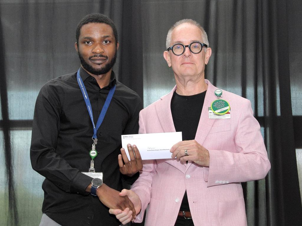 Opeyemi Iwaloye receives an award at the 2026 O'Neal Research Retreat.