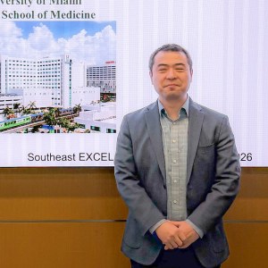 Zhipeng Meng, Ph.D., standing in WTI 101 in front of a PowerPoint presentation.